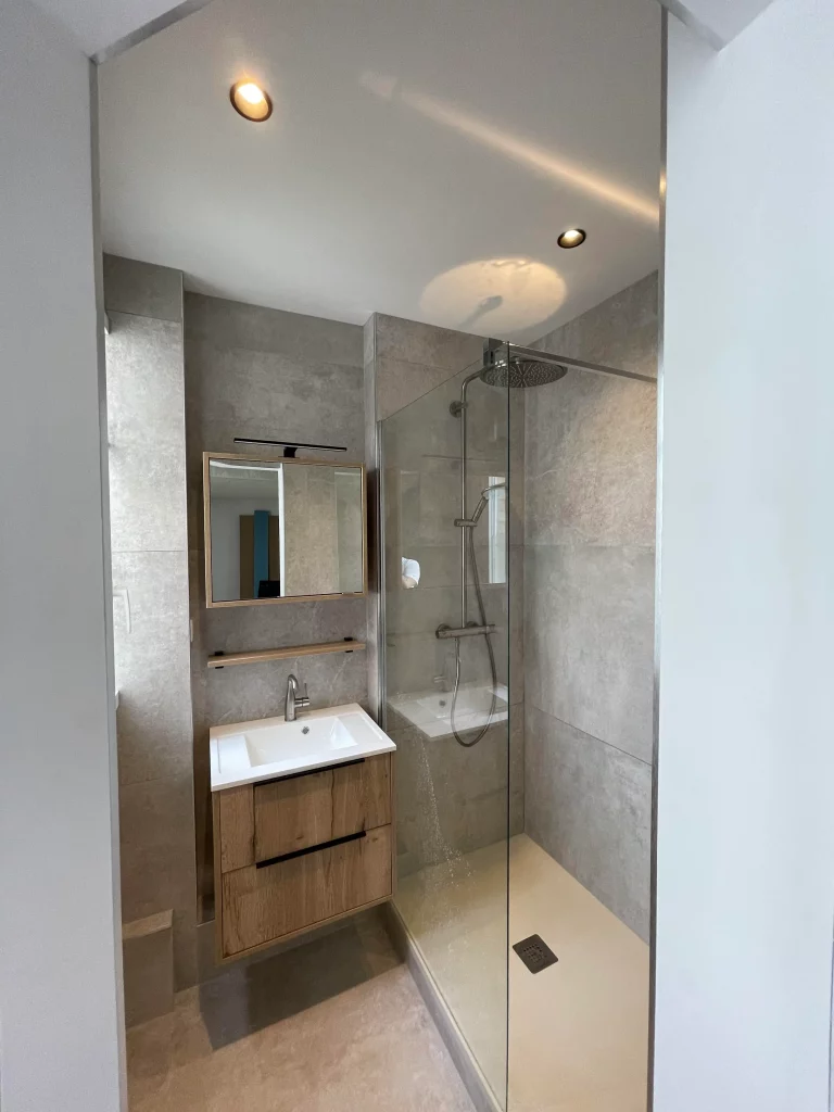 Salle de bains rénovée douche et lavabo