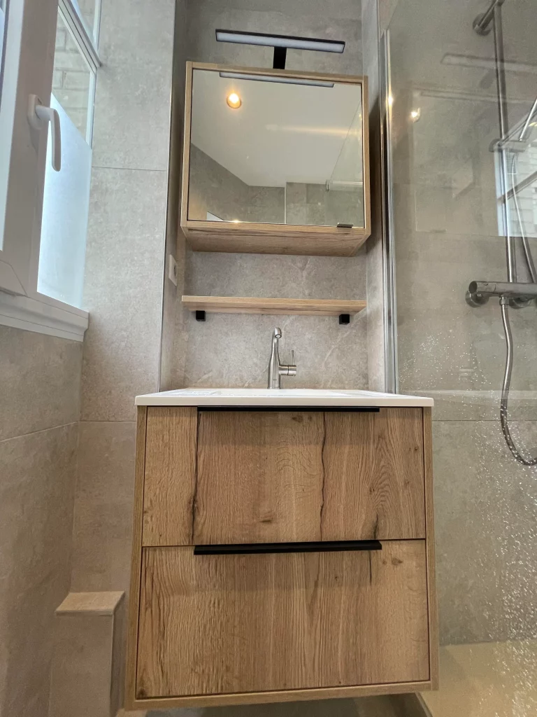 Salle de bains rénovée douche et lavabo