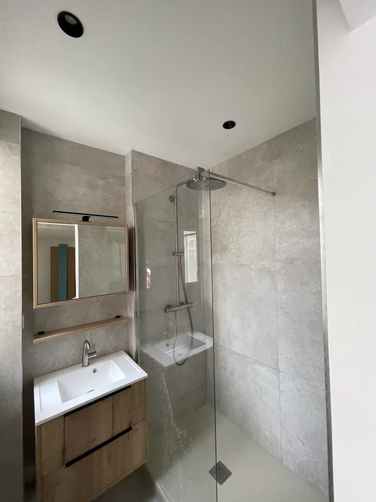 Salle de bains rénovée douche et lavabo